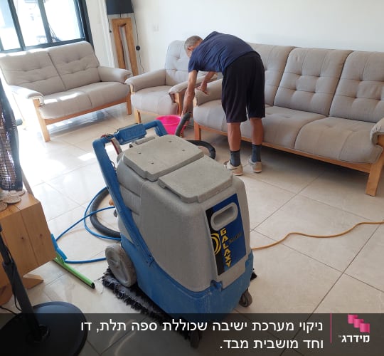 אדם מנקה ספה עם מכונת ניקוי מקצועית